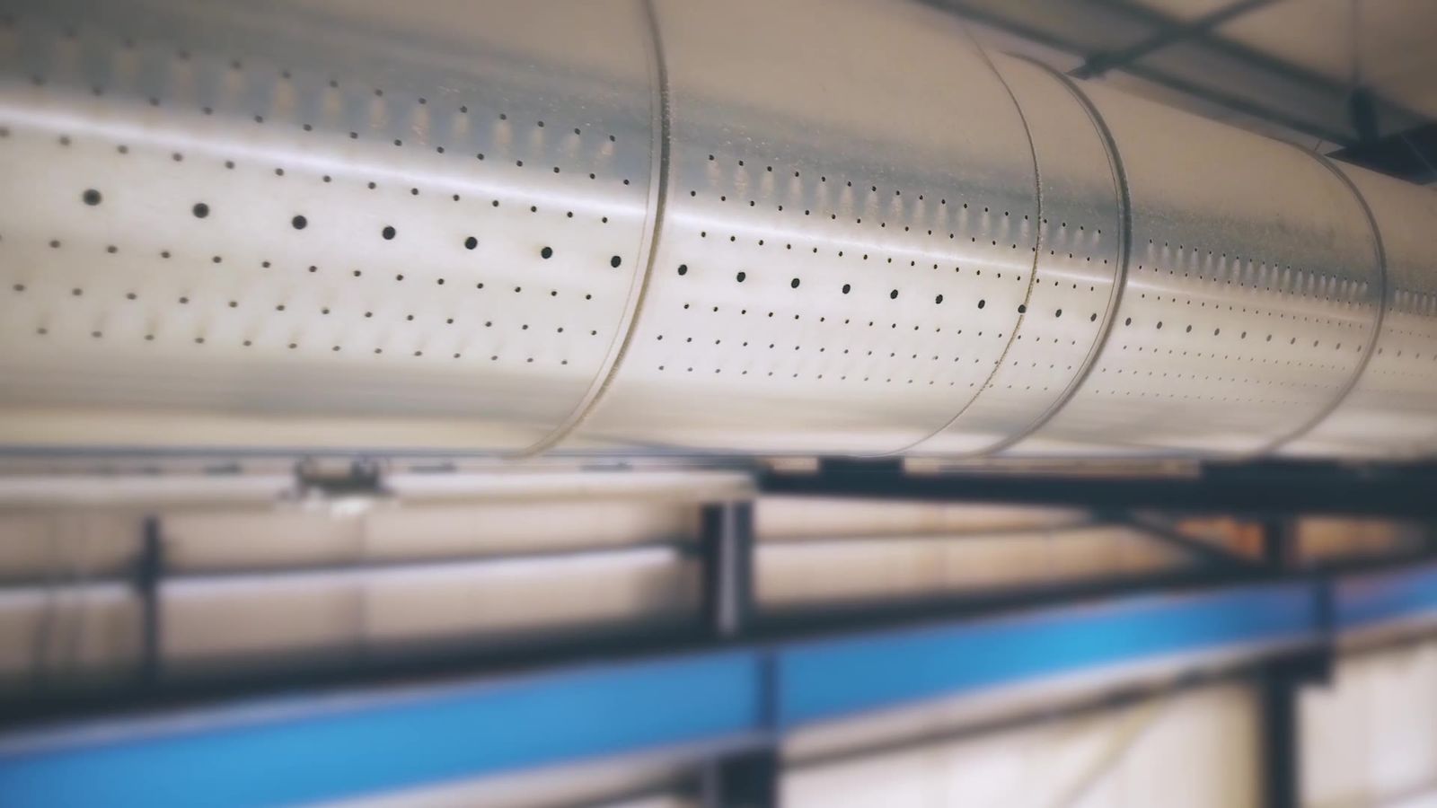 Filmed close-up of perforated ductwork installed in a building